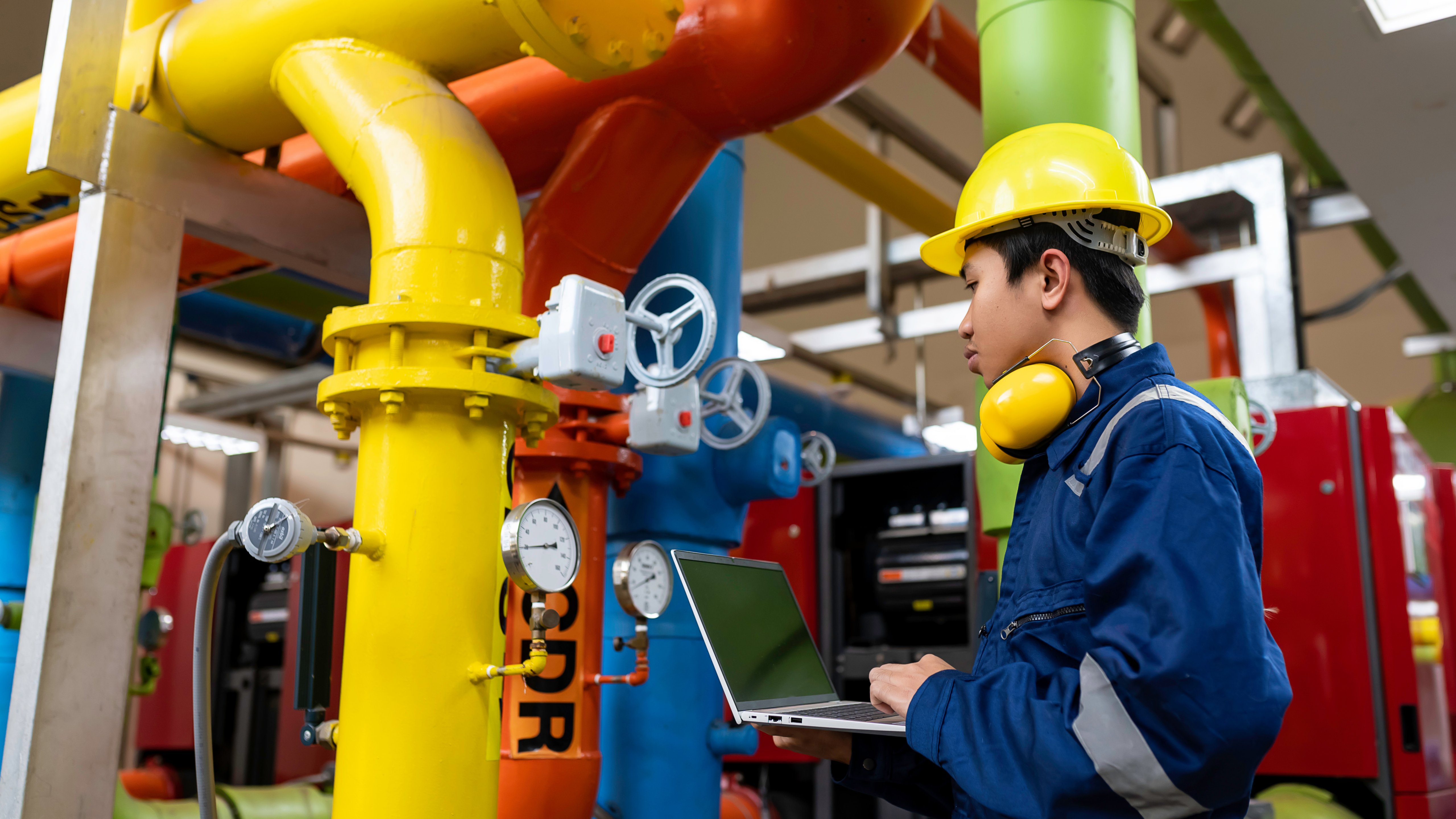 Maintenance technician at a heating plant,Petrochemical workers supervise the operation of gas and oil pipelines in the factory,Engineers put hearing protector At room with many pipes