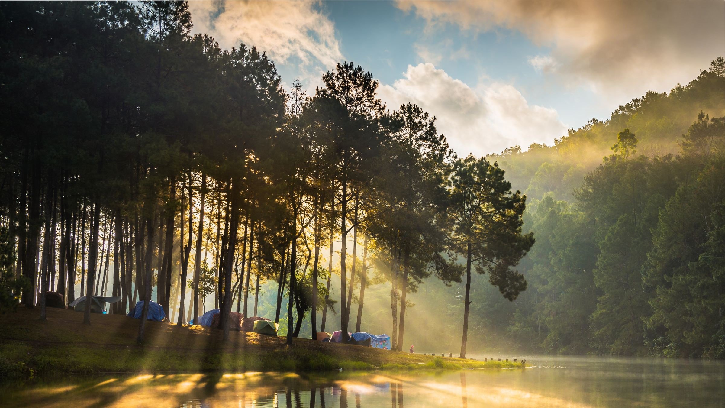 Tents on a tree lined river bank, Pang Ung, Thailand