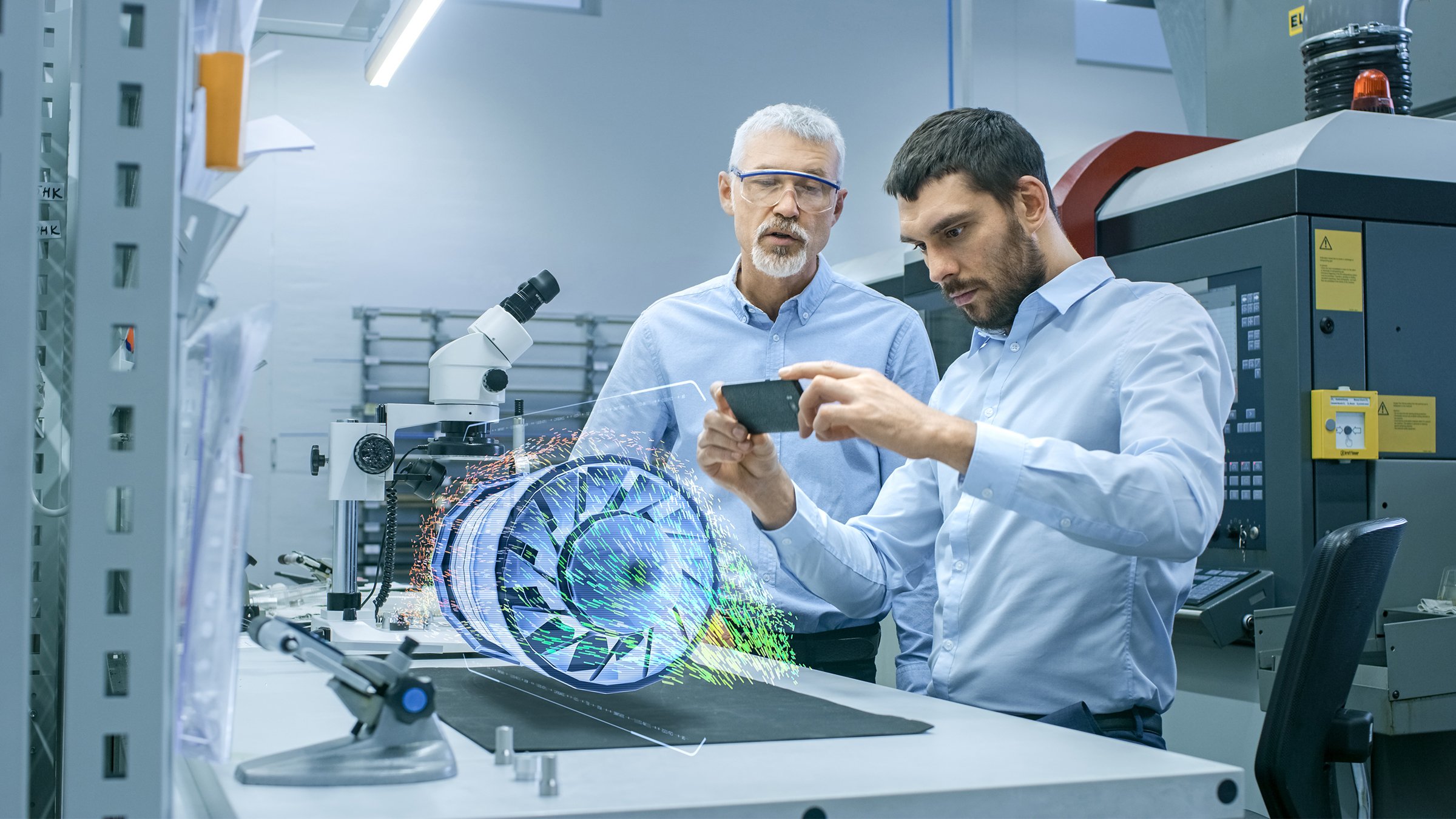 Two Engineers Works with Mobile Phone Using Augmented Reality Holographic Projection 3D Model of the Engine Turbine Prototype. Development of Virtual Mixed Reality Application.