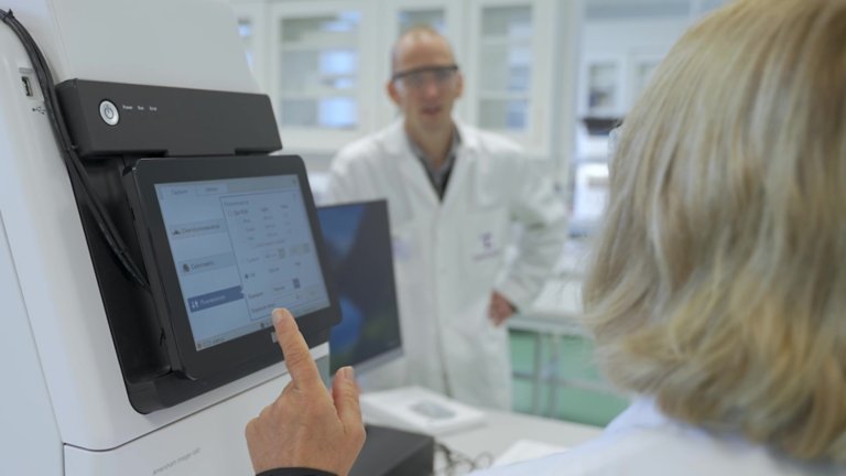 Testa Center CEO Lotta Ljungqvist points to a digital screen while talking to Director Jesper Hedberg at the organization's facility in Sweden.