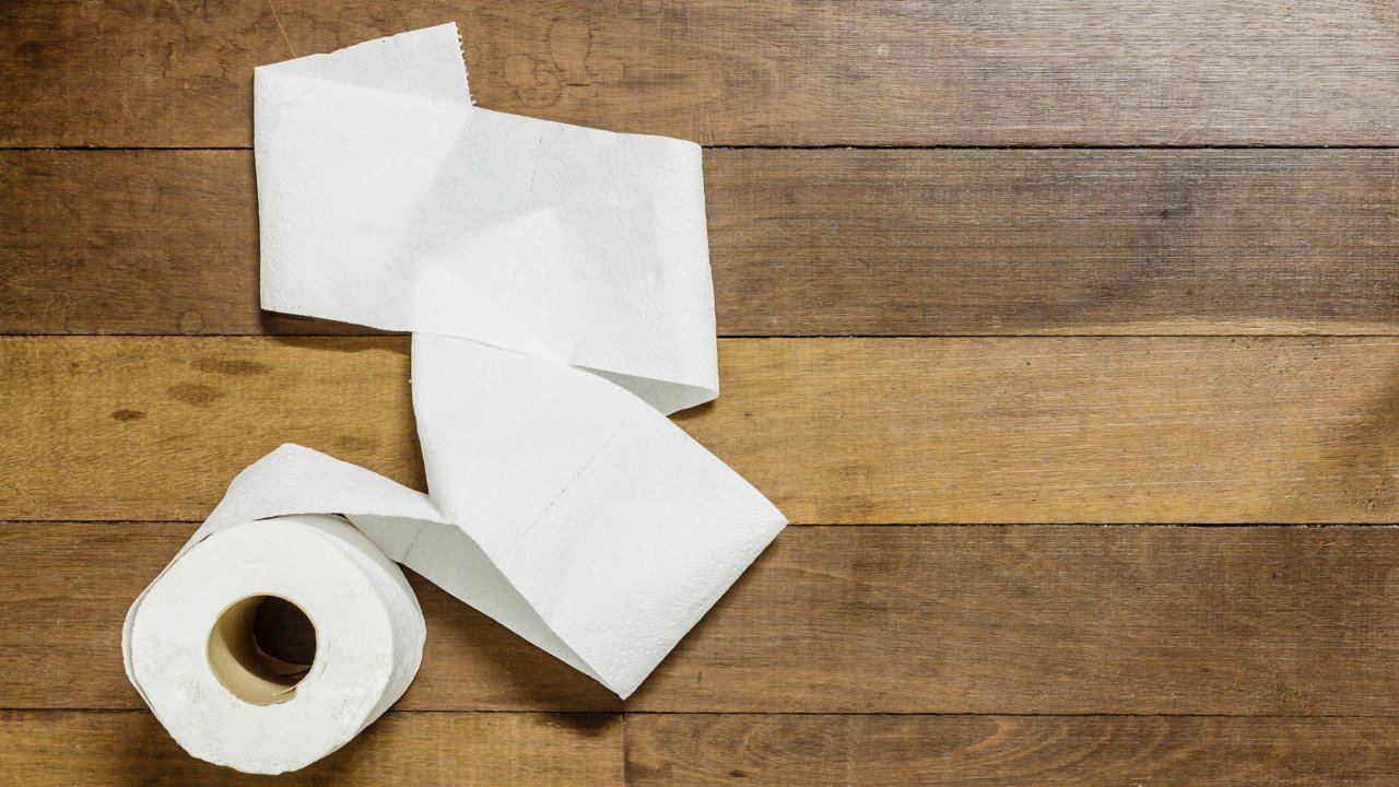 Toilet paper roll on wooden floor