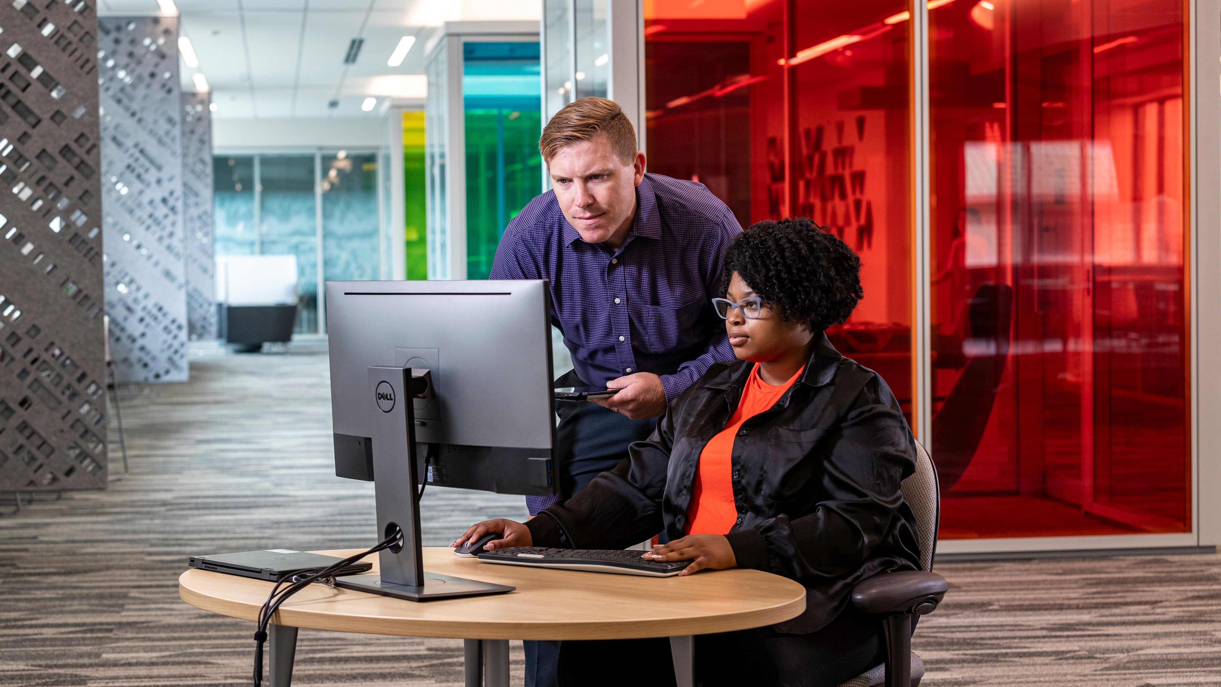 Two people looking at a screen in a conference area