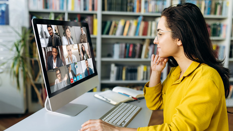 Una mujer sentada en un escritorio, participando en una videoconferencia