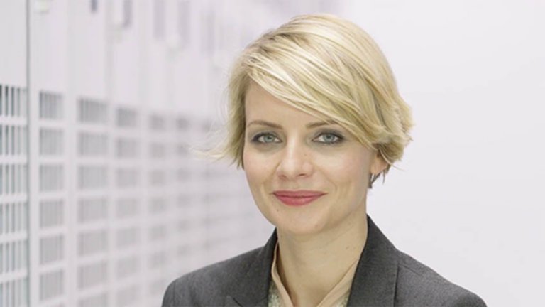 Headshot of a woman with short blonde hair standing in industrial data center