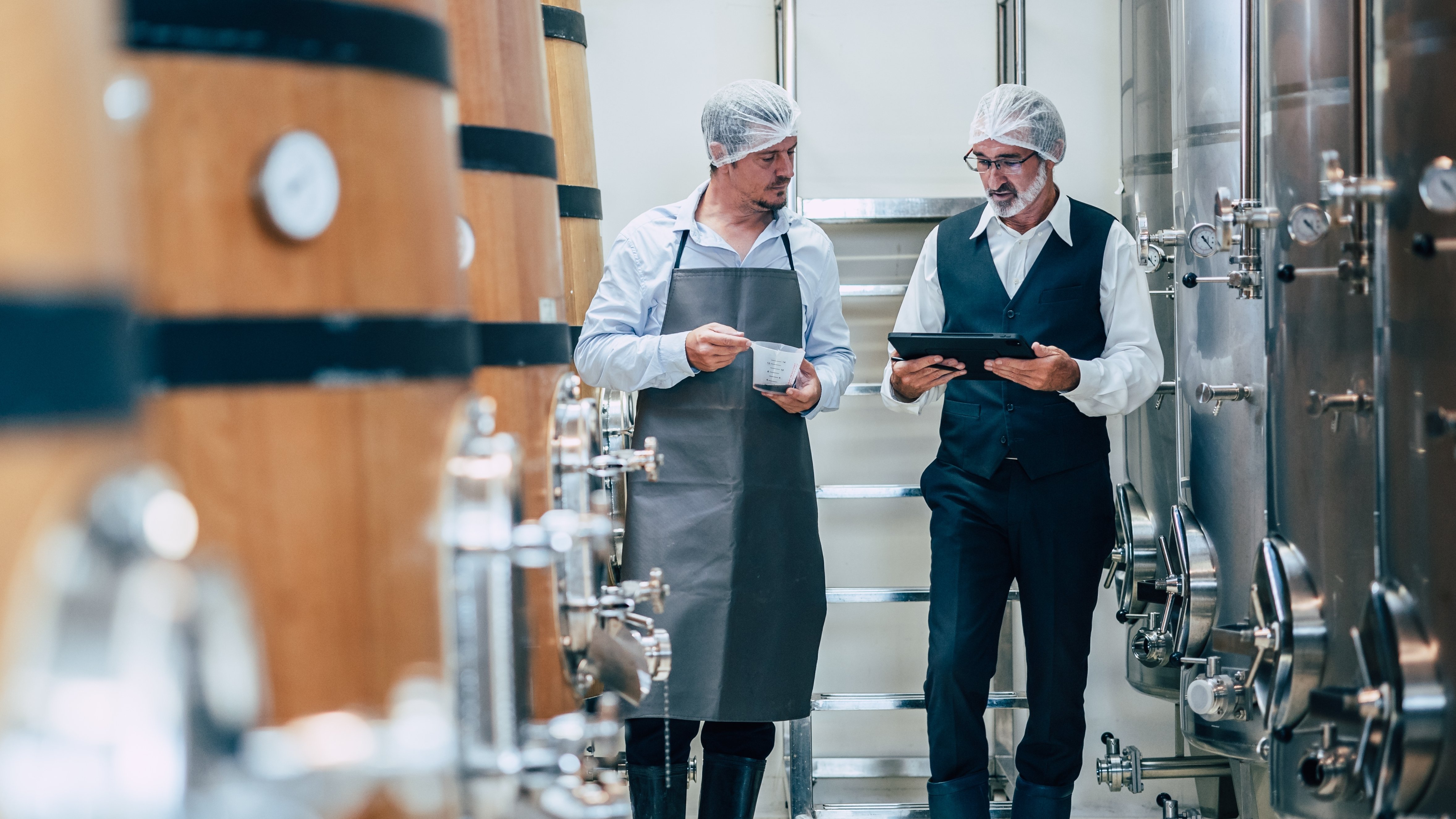 Winemaker working in modern large winery factory liquor drink industry quality and fermentation monitor 