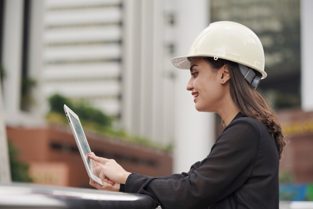 woman-engineer-wearing-white-helmet-at-construction-site-use-computer-tablet