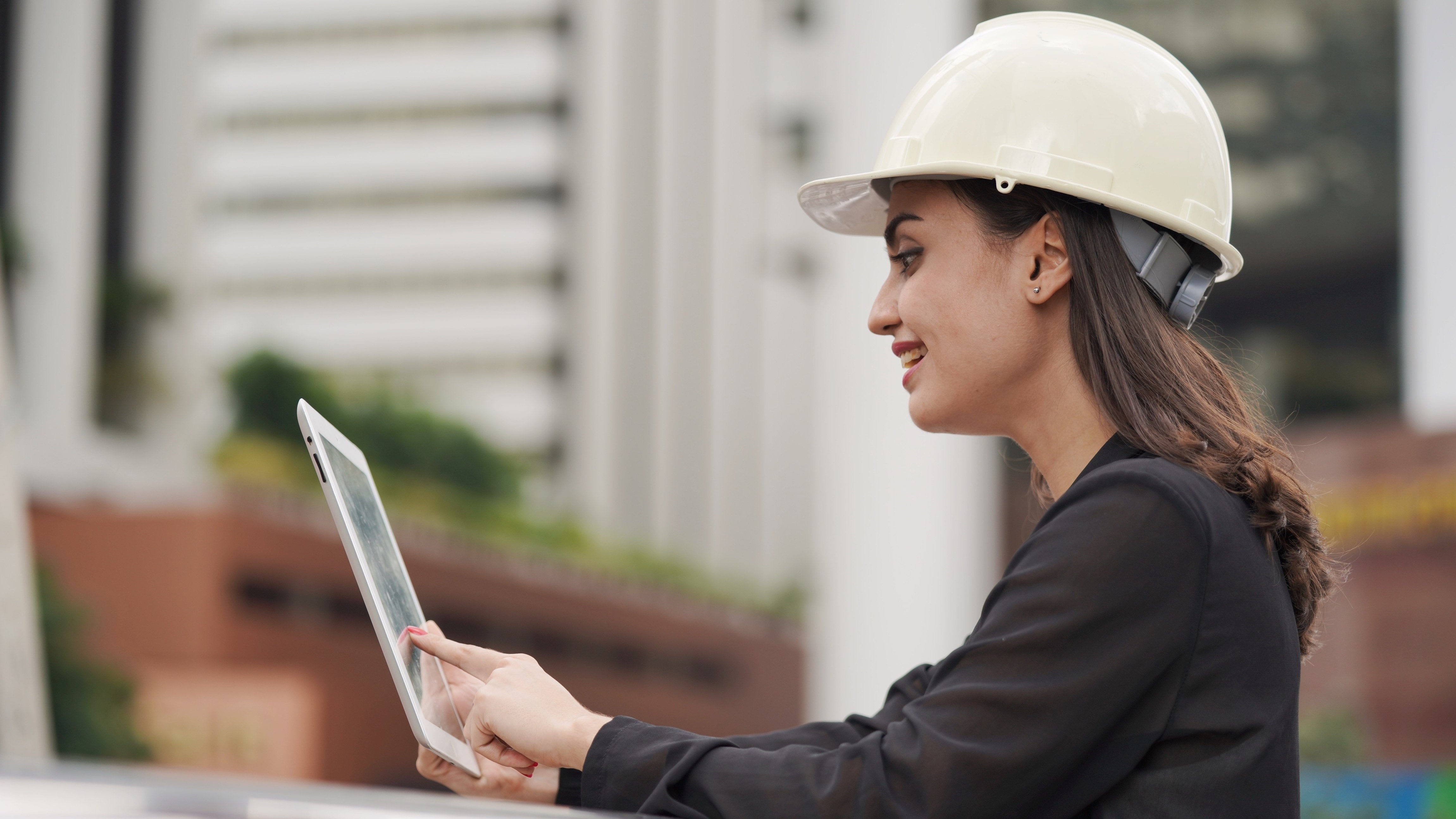 woman-engineer-wearing-white-helmet-at-construction-site-use-computer-tablet