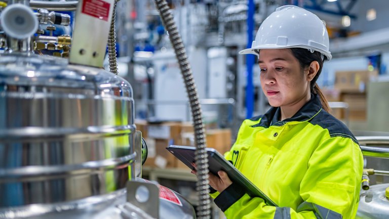 Asian engineer working at Operating hall,Thailand people wear helmet  work,He worked with diligence and patience,she checked the valve regulator at the hydrogen tank.