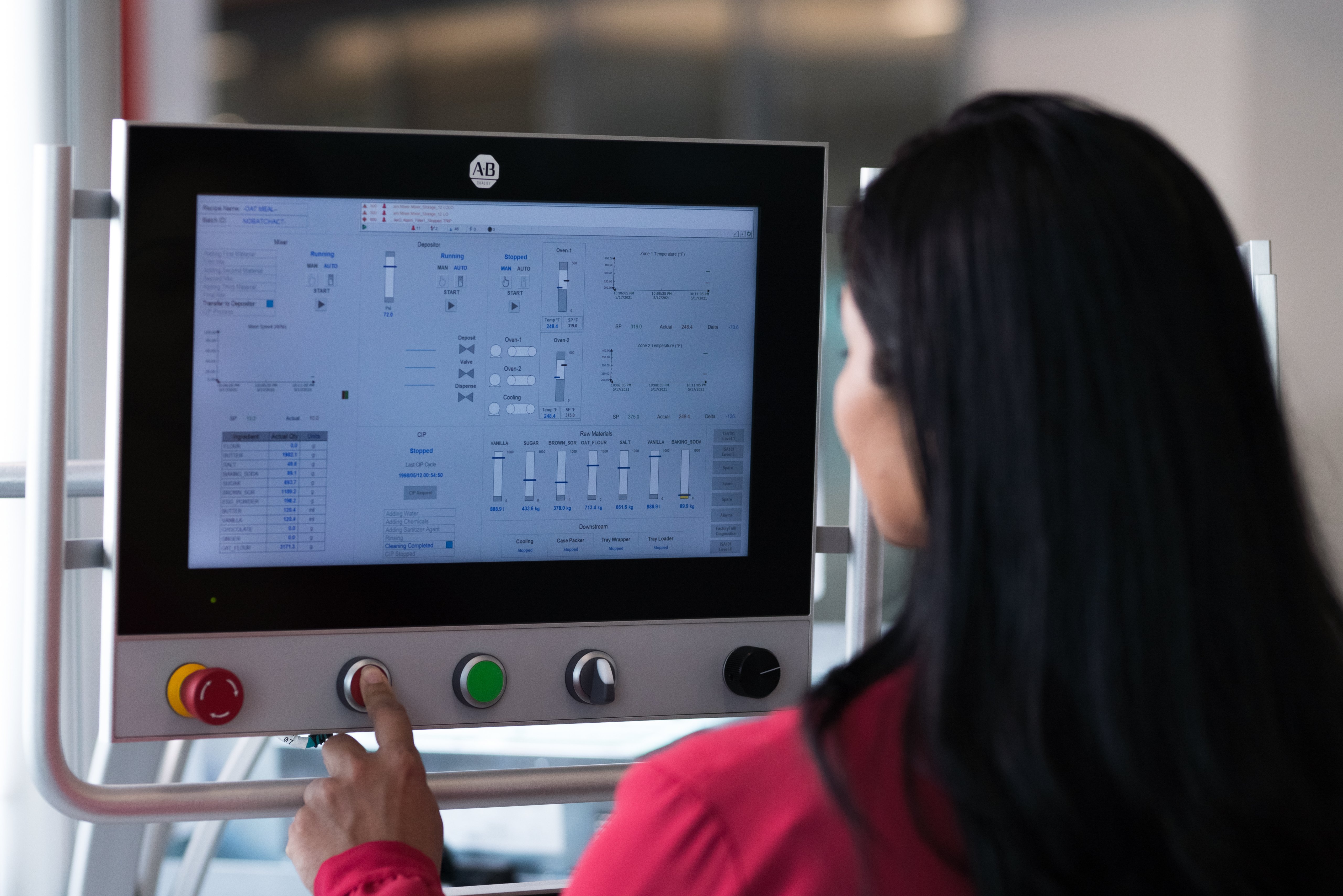 Female worker pressing an HMI touchscreen