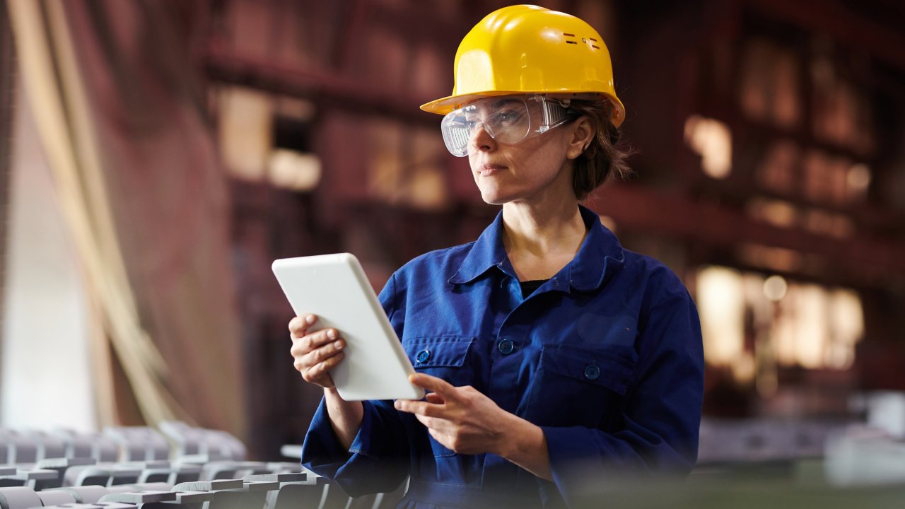Woman worker with protective glasses yellow hat and tablet