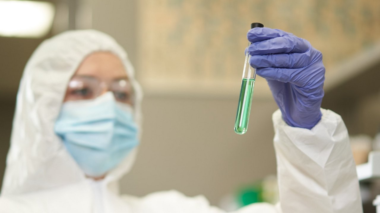 Woman in lab holding liquid tube.
