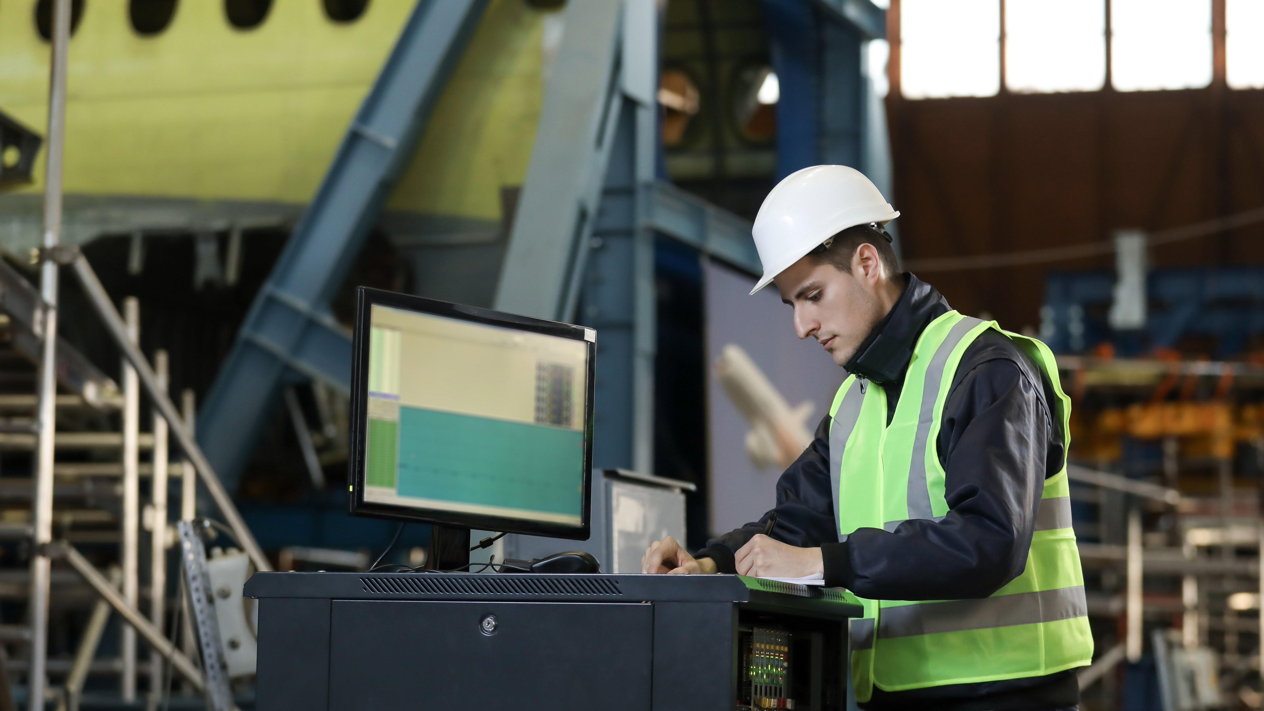 Portrait of a man , factory engineer in work clothes controlling the work process at the airplane manufacturer.