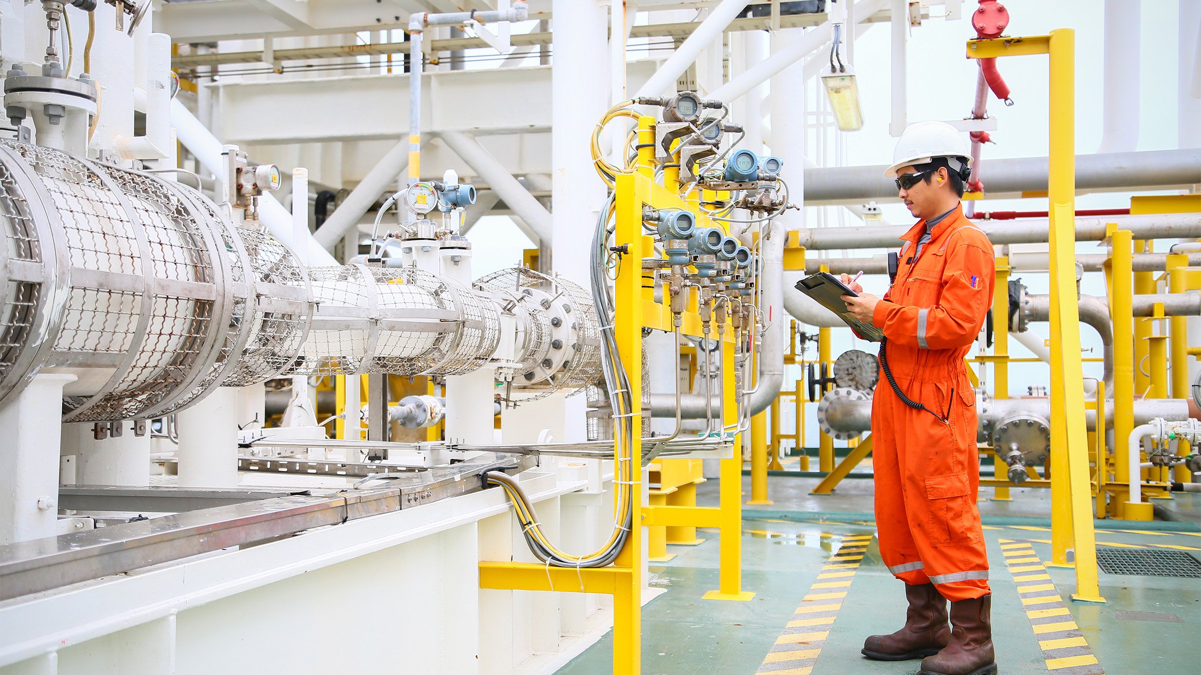 Worker monitoring oil and gas processes on an offshore oil rig.