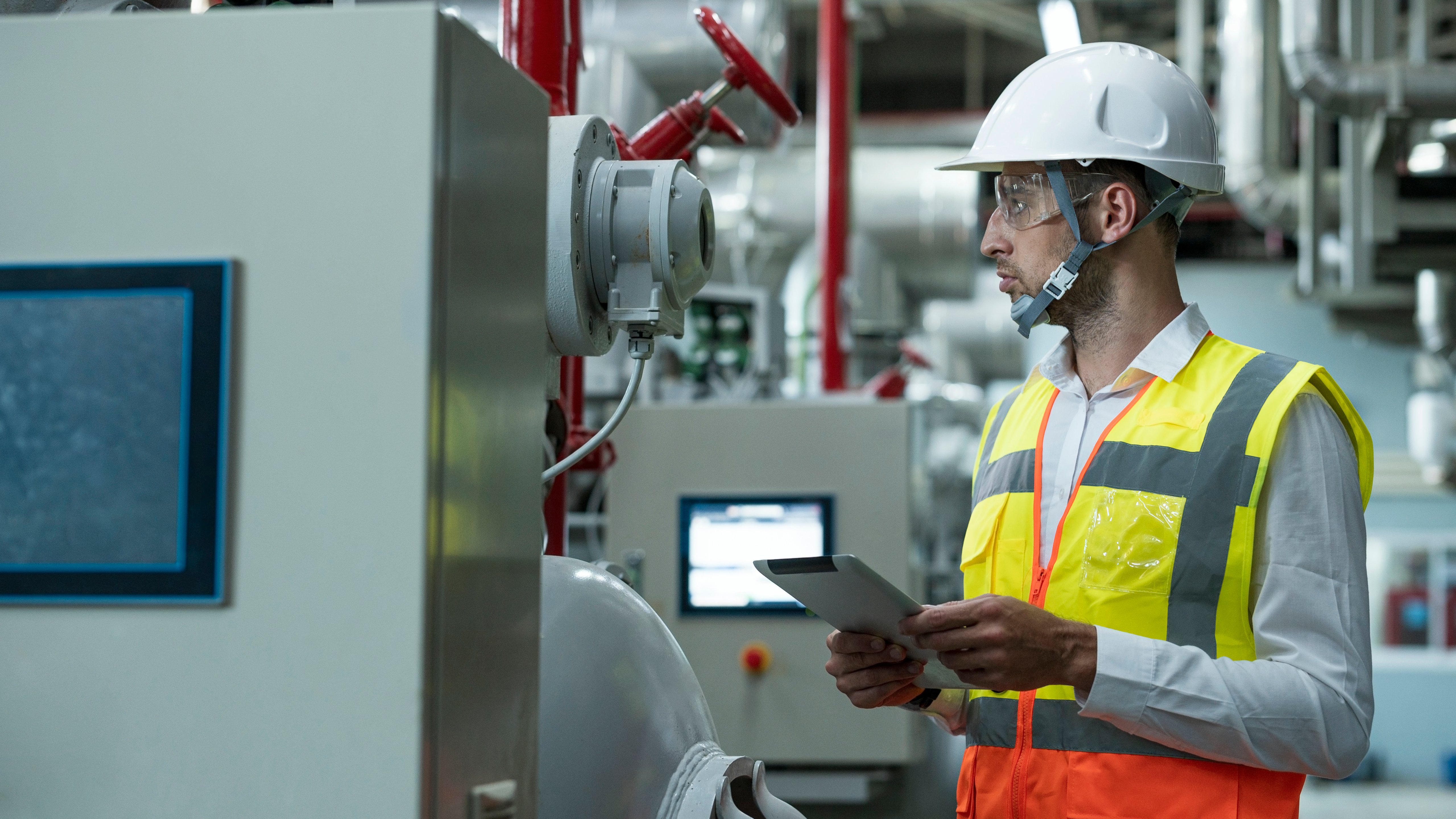 Side view of Mature Businessman using tablet while safety checking in boiler system room at food processing industry. Boiler water supply system for production line process.