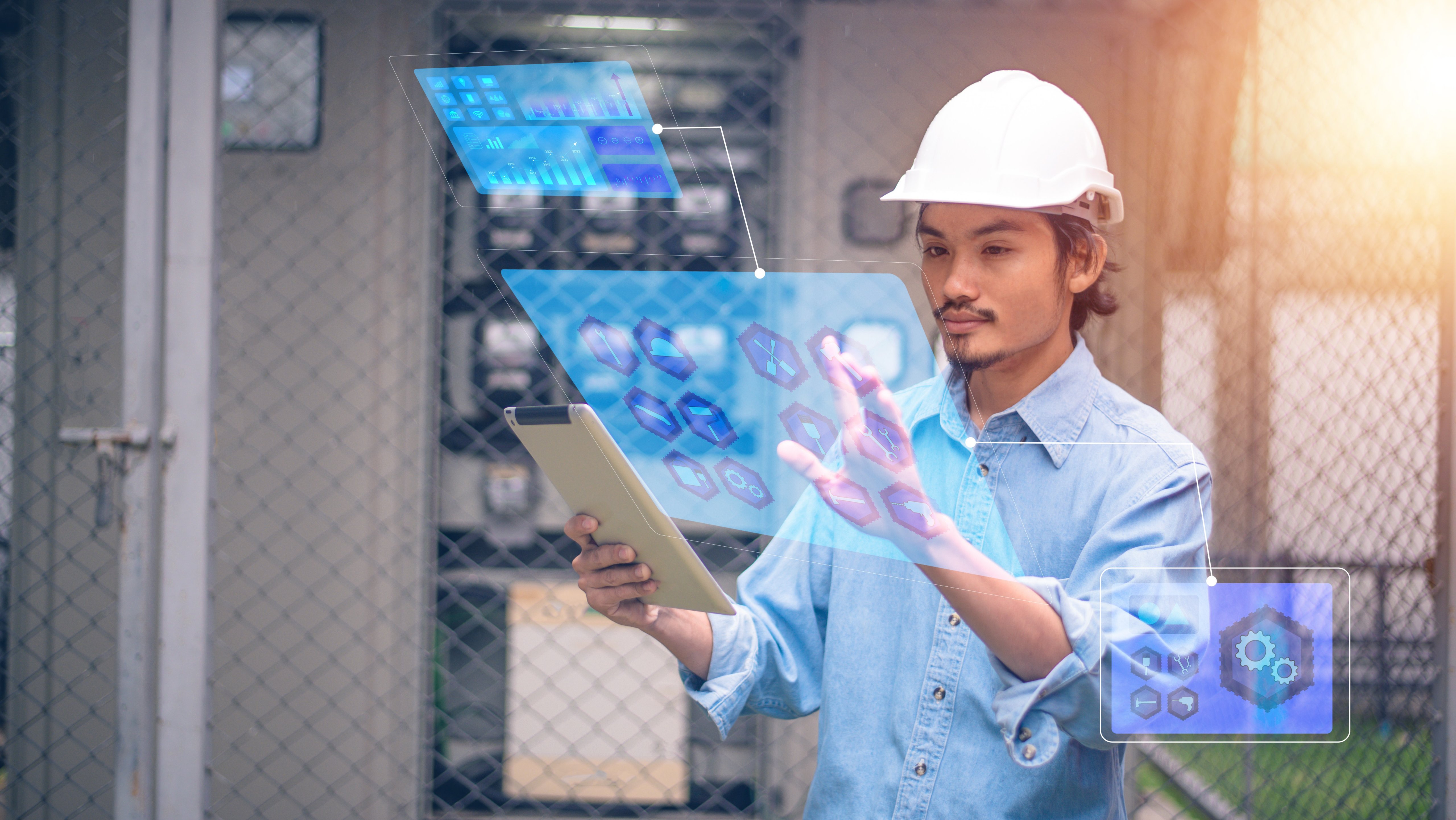 Electrician using tablet checking electric system for factory plant.