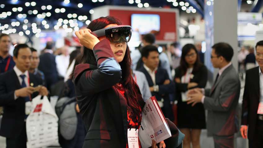 Woman wearing virtual glasses in exhibition.