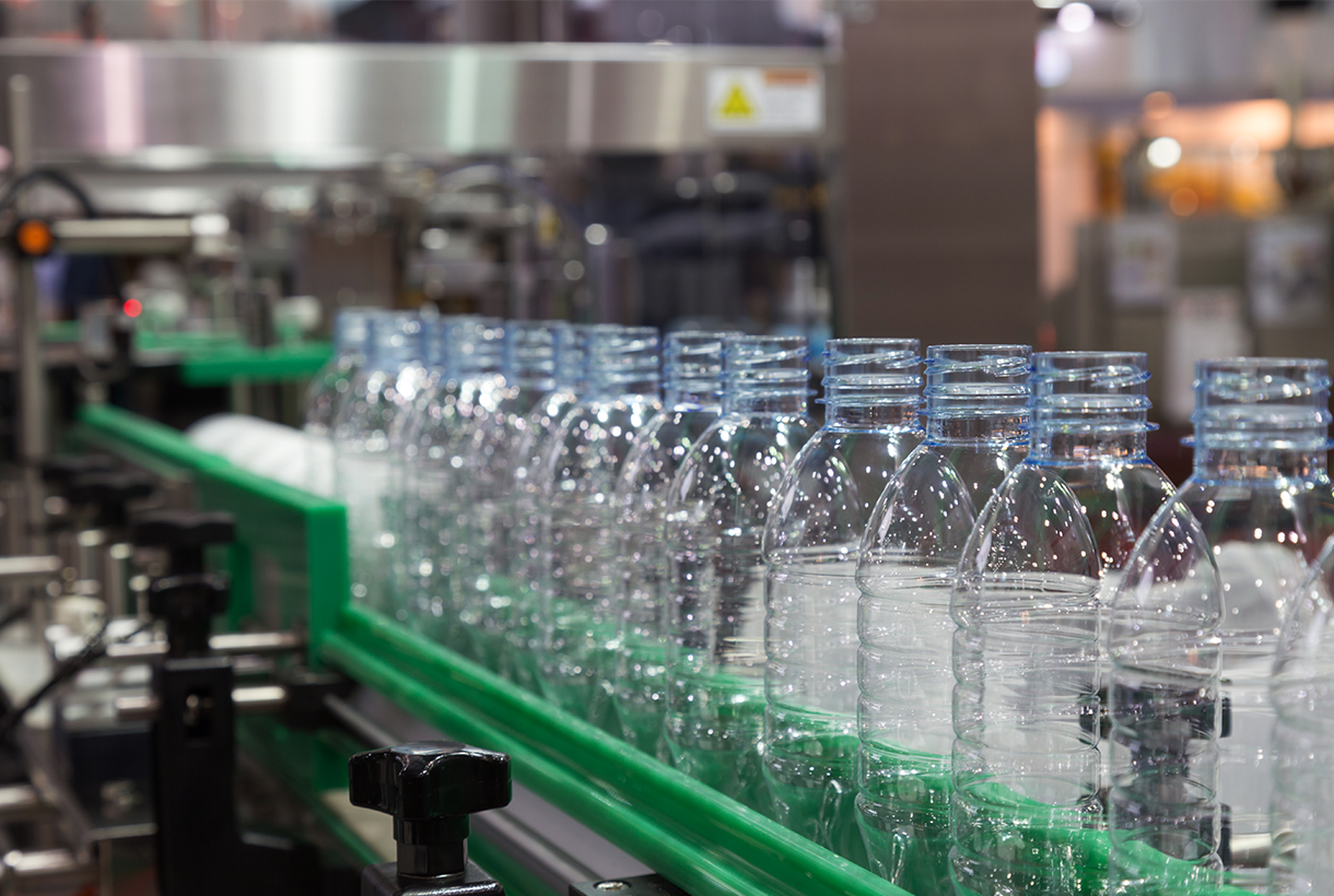 Clear plastic bottles on liquid filling line