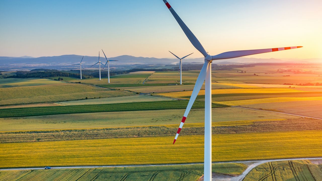 Windmills in an open field converting wind power into rotational energy for a renewable source of power