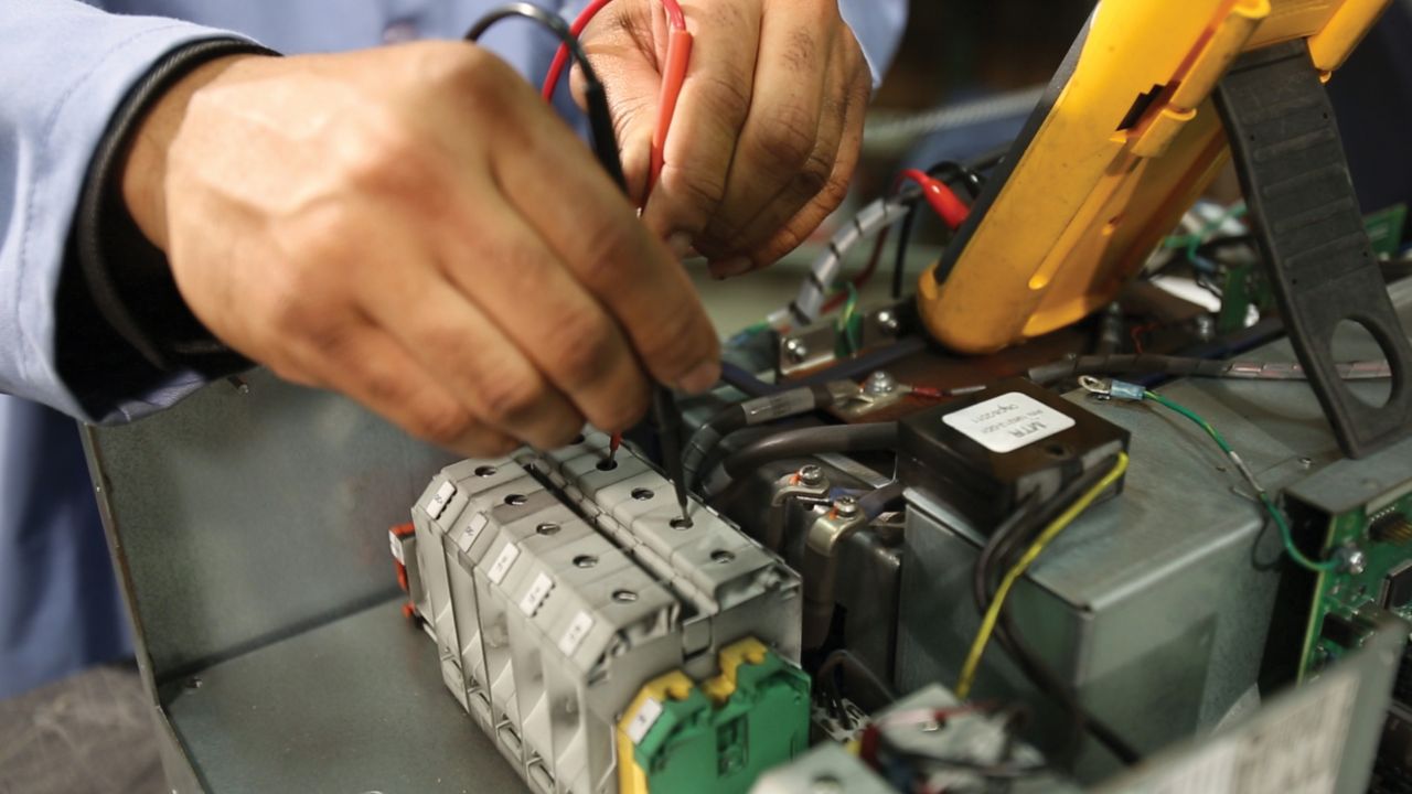 Close-up of a repair technician testing a PowerFlex drive