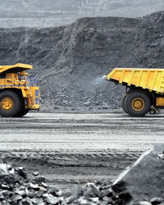 Two dump trucks driving at a mining site