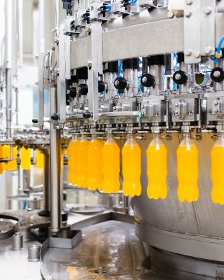 Instalações industriais de bebidas exibindo o processo automatizado de encher garrafas
