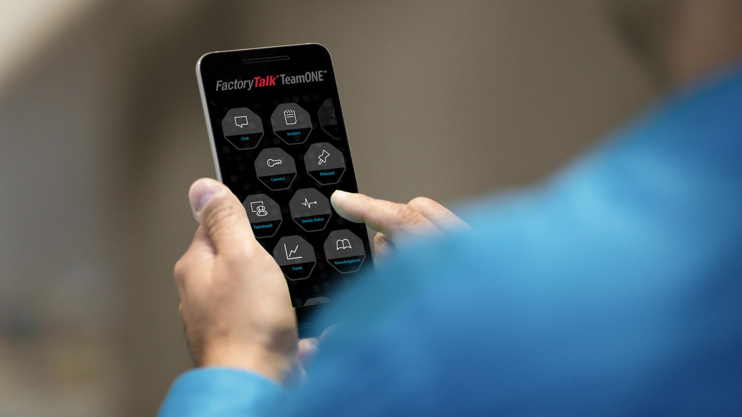 Rockwell Automation employee navigating through the FactoryTalk TeamONE application on his phone