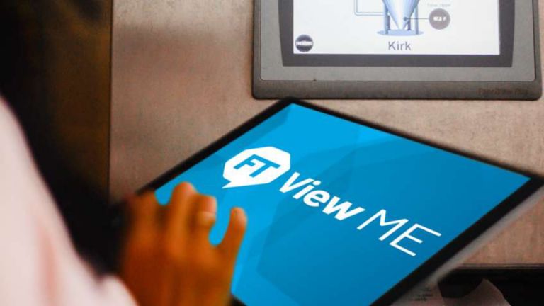 Un employé saisissant des informations sur une tablette qui affiche un logo FactoryTalk View Machine Edition à l’écran