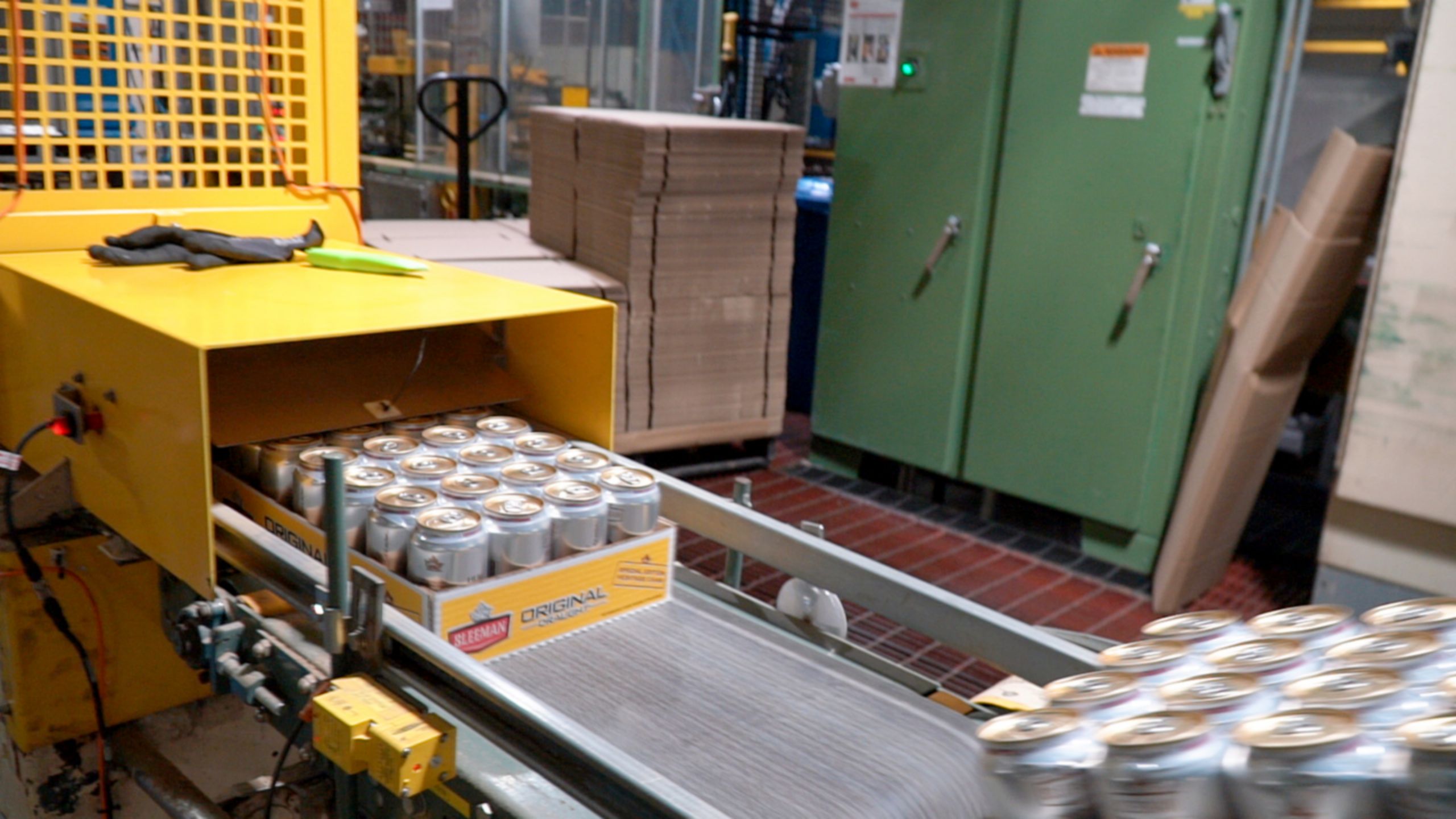 Packaged canned beverages moving along a conveyor