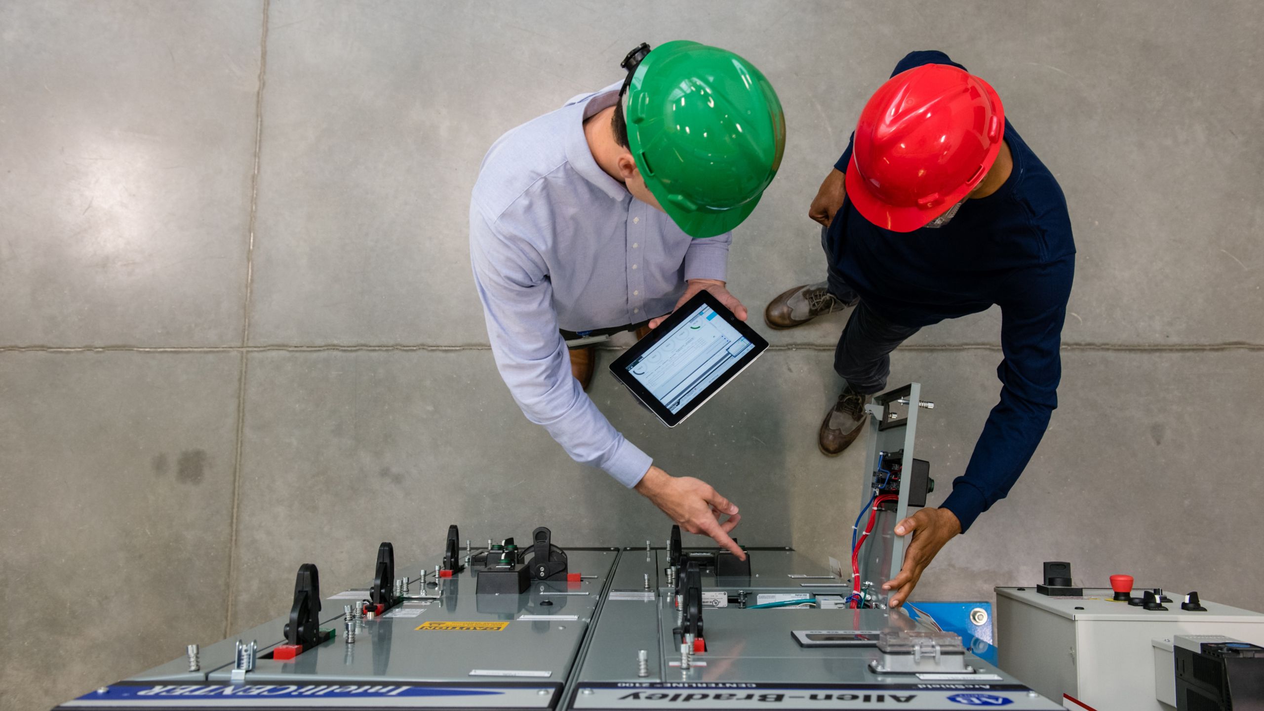 Deux employés d’usine visualisant une tablette placée devant un produit Rockwell Automation