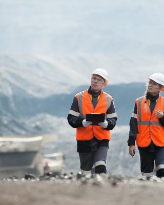 Dos empleados de la mina caminan y observan un sitio minero