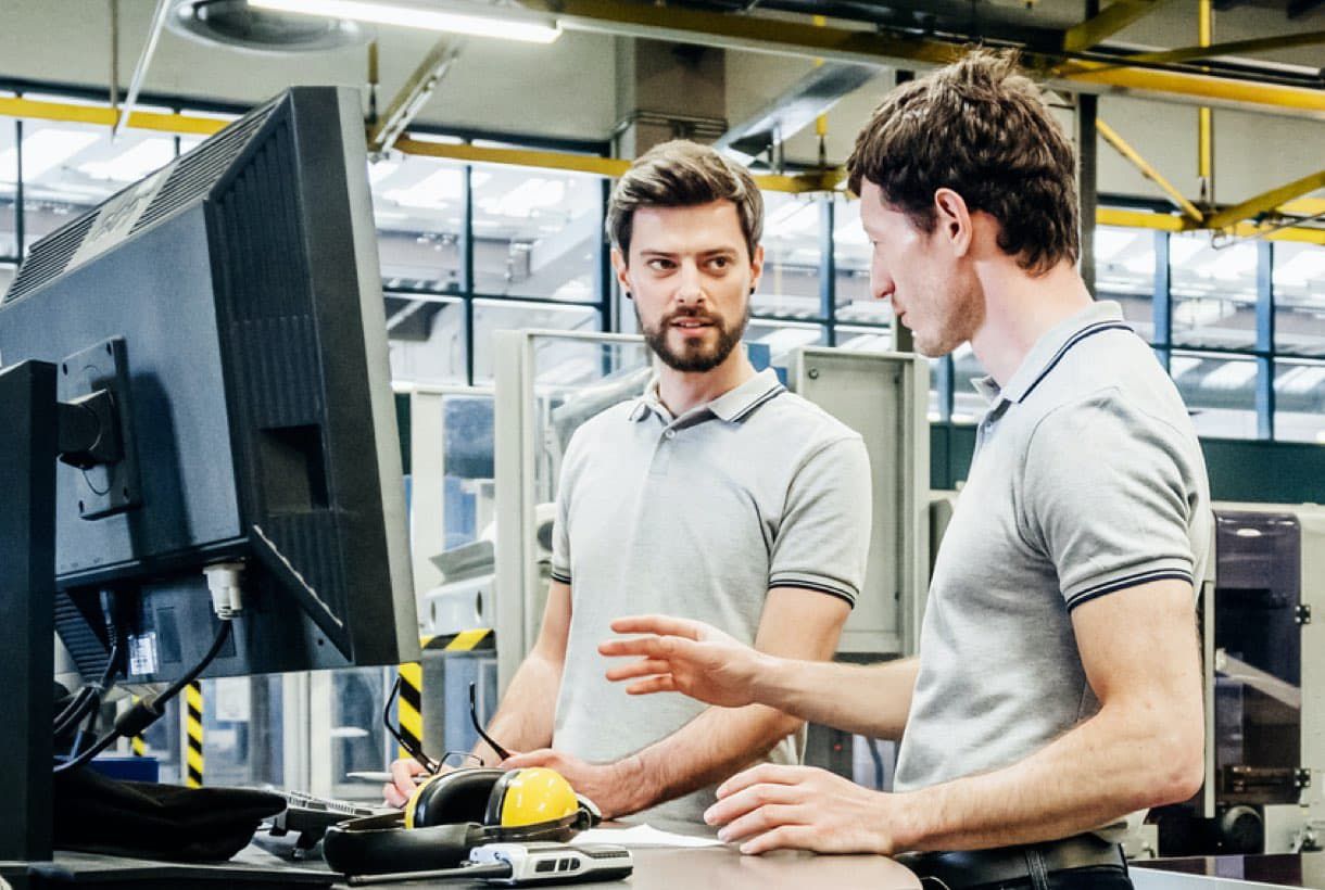 Two shop engineers collaborating at workstation