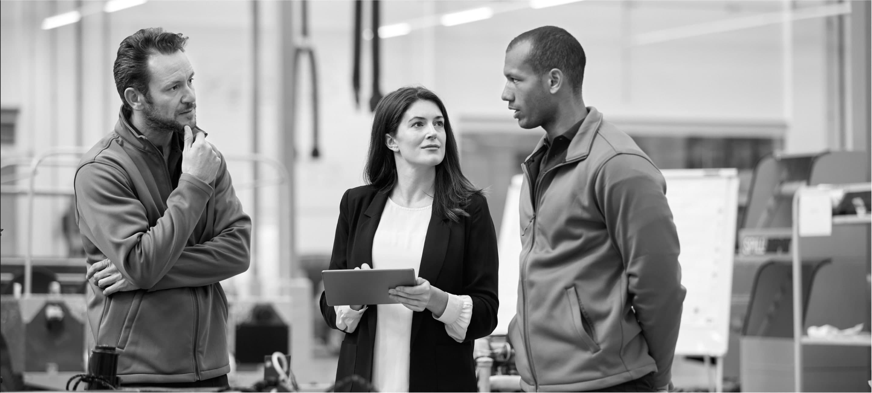 standing office managers collaborating over tablet into