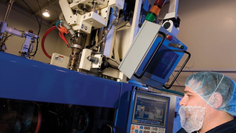 Um representante da Advanced Scientifics Inc. inspeciona um equipamento grande usado na fabricação do setor de ciências da vida.